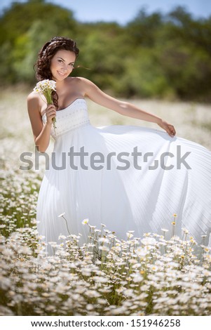 beautiful girl holding bouquet camomile flowers. attractive woman walking at field outdoors. happy young woman on nature. healthy teenager girl natural  makeup. freedom concept. Woman with chamomile
