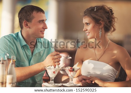 Happy loving Couple in Cafe, man and woman at romantic dating. Man and woman talking in a cafe restaurant. young men whispers to his girlfriend, couple in love. Hugging couple. man and woman in love