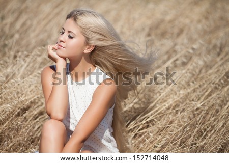 beautiful young Caucasian woman outdoor, healthy sensual girl at wheat field. Happy  blonde woman resting. Natural makeup hairstyle. long hair perfect skin. young woman outdoors. Natural blond hair