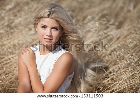 Healthy Young woman outdoors on nature. Happy smiling teenager girl at wheat field. skin and hair care. natural long blonde hair. autumn girl. Attractive pretty girl at wheat field. Sensual blonde.