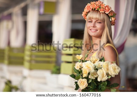 Happy smiling woman with flowers outdoors. Attractive teenager girl walking. Natural beauty woman with flowers. France. Pretty young woman outdoors.