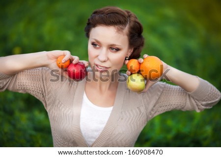 Autumn woman happy smiling outdoors, beautiful Woman holding autumn apples and fruits. Portrait of young woman walking outdoors at fall. Attractive woman walking in autumn park.