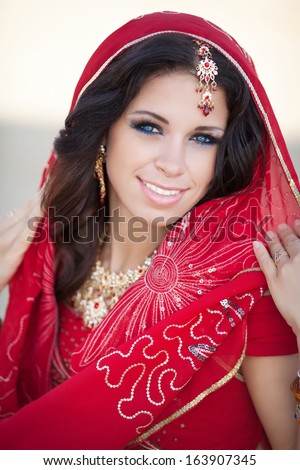 Beautiful Indian Woman in traditional dress walking outdoors. Portrait of young Indian girl. Indian beauty.
