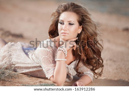 fashion portrait of sexy delicate woman, vogue style girl with long curly hair outdoors. Portrait of young sensual woman. Tan Woman in salty desert.