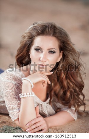 fashion portrait of sexy delicate woman, vogue style girl with long curly hair outdoors. Portrait of young sensual woman. Tan Woman in salty desert.