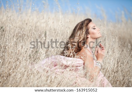 beautiful sexy woman in field Outdoor portrait. delicate sensual woman on nature. perfect skin, curly hair, sexy body
