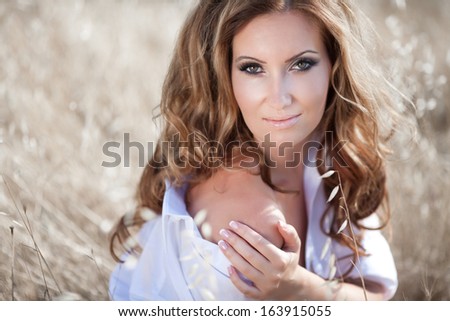 beautiful sexy woman in field Outdoor portrait. delicate sensual woman on nature. perfect skin, curly hair, sexy body