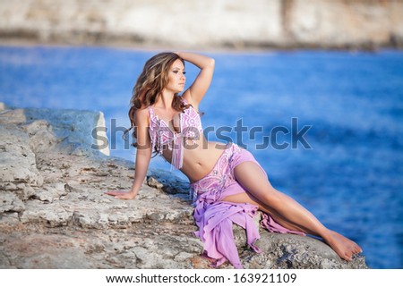 Beautiful sexy woman bellydancer in purple dress outdoors. Professional arabian dancer portrait. exotic star of bellydance.