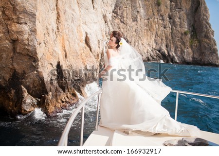 Bride and groom on yacht at wedding day. Luxury wedding. Happy newlyweds outdoors.