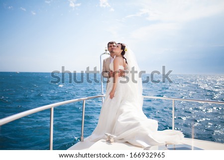Bride and groom on yacht at wedding day. Luxury wedding. Happy newlyweds outdoors.