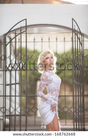 Beautiful sexy blond woman in golden dress, beauty and fashion girl. Vogue style bride. Retro woman portrait outdoors. Luxury. Glamour woman with blonde curly hair and bright makeup.