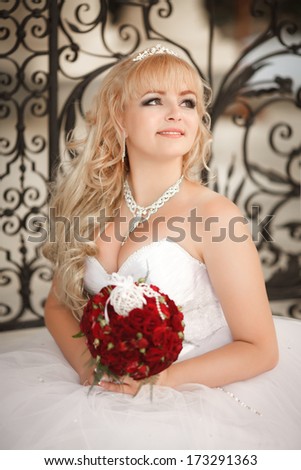 Beautiful Bride Wedding Portrait Outdoors, newlywed woman in wedding dress with bridal flowers. Happy Bride posing in on nature.
