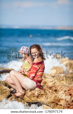 Happy mother and child playing at beach at summer lifestyle, happy family vacation. Young woman with son resting at sea. Series.