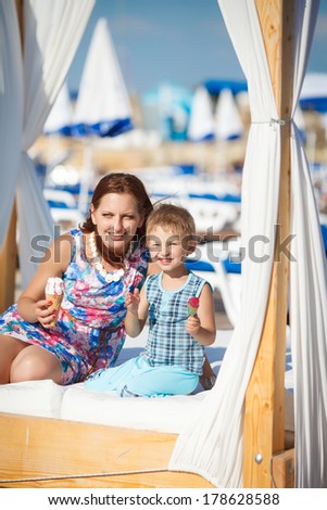 Mother and child at summer beach vacation, happy family resting near sea lifestyle portrait. Woman and son playing on nature. Series