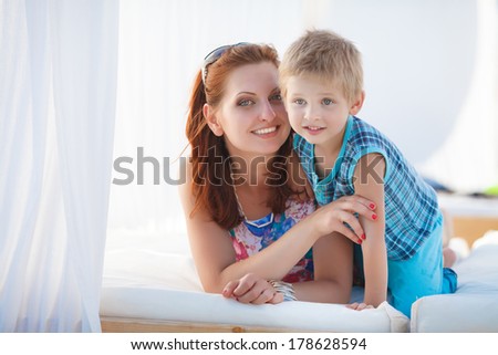 Mother and child at summer beach vacation, happy family resting near sea lifestyle portrait. Woman and son playing on nature. Series