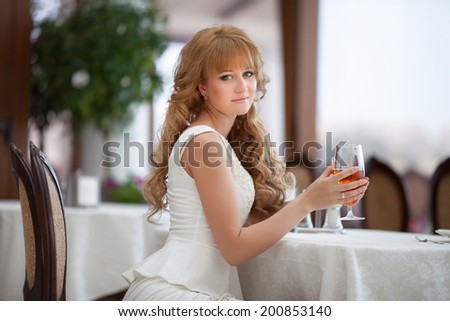 Beautiful young woman in restaurant, girl drink juice in cafe.