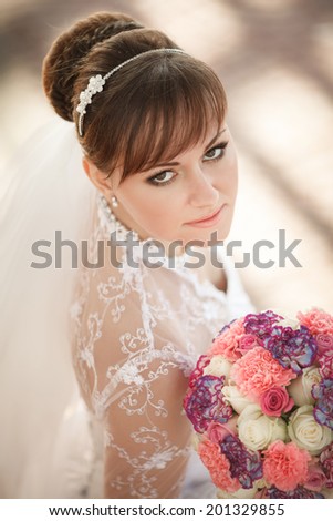 Beautiful young bride with wedding makeup and hairstyle, attractive newlywed woman wedding flowers. Happy Bride waiting groom. Marriage Wedding day moment. Bride portrait. soft tonality