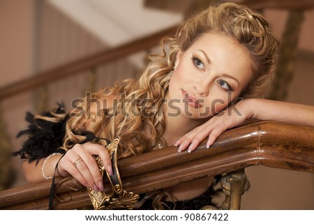 Fashion luxury retro portrait of beautiful sexy young woman with venice golden mask in the theater hall classic Interior art girl blond hair closeup