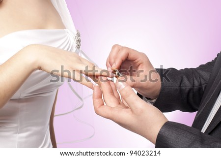 Hands with rings Groom putting golden ring on bride\'s finger during wedding ceremony Loving couple closeup in studio isolated portrait on white background