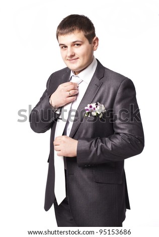 stock photo Wedding portrait of elegant groom in grey satin suit puts on