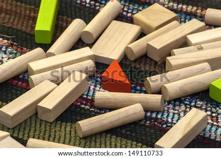 Elements of children\'s wooden sorting and stacking toys on homemade rug