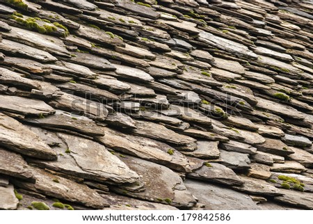 Stone tiles of slate-roof rural house as background