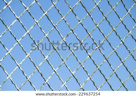 Old grunge fence net on blue sky background