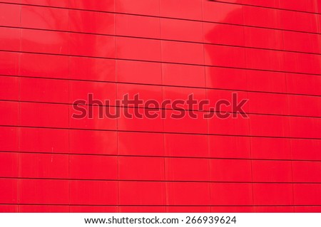 Red metal panel wall of contemporary office building facade closeup as background