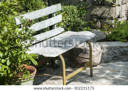 Old wooden garden bench in house backyard