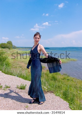 The young nice girl dances east dance on coast of lake