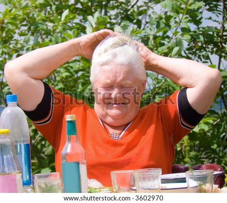 Photo of the elderly woman behind a table during a holiday on the nature