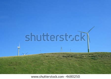 Wind energy generators of electric energy on a green hill