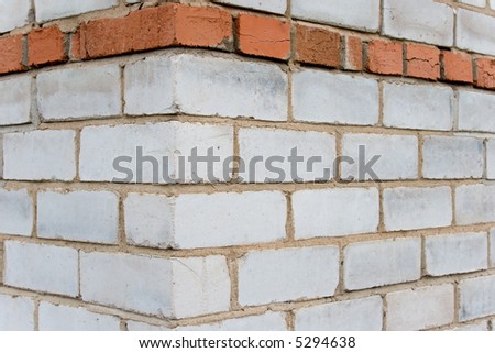 Corner of the house constructed on the basis of a silicate and ceramic brick. A background on a theme about construction.
