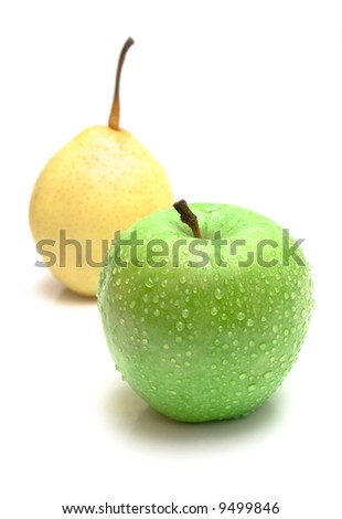 The ripe juicy apple covered by drops of water. Behind of a apple the pear lays. Isolation on white, shallow DOF.