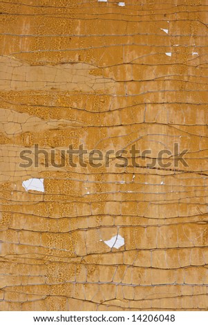 Old wall painted with the beige paint, cracked from time
