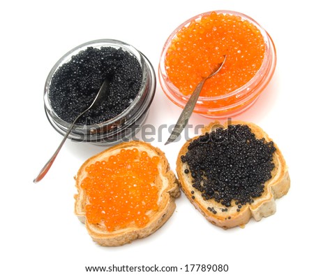 Red and black caviar on white. Dissertations stick out of jars with caviar metal. Isolation, shallow DOF.