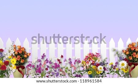 A white fence in the garden with flowers and plants