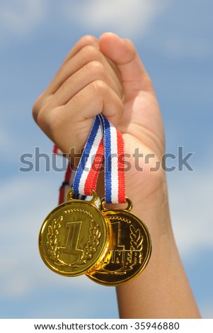 hand hold gold medal in blue sky background