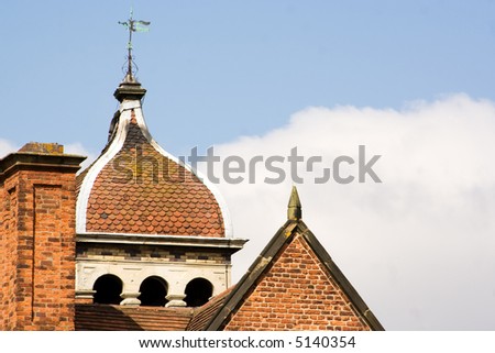 close up of roof on old English mansion house with sky background