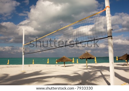 beach volley ball net with sun shades and turquoise sea