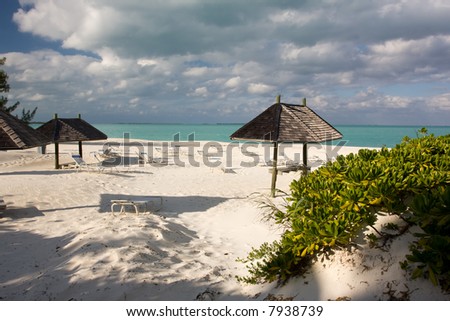sun loungers and thatched sun shade on deserted beach
