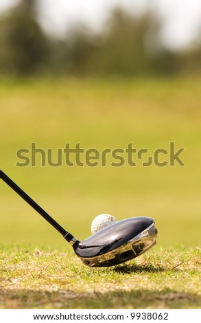 close up of driver golf club, and golf ball with reflection of golfer in club
