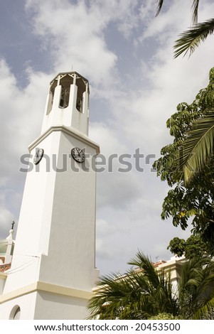 white church bell and clock tower against blue sky