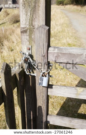 wooden gate secured with a padlock and chain