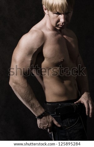 Closeup of muscular male bodybuilders arm, black background.