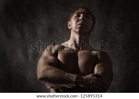 Half body portrait of bare chested bodybuilder posing