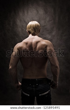 Highlighted back of male bodybuilder showing muscle definition.
