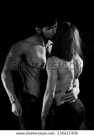 Athletic young couple in the studio on a black background