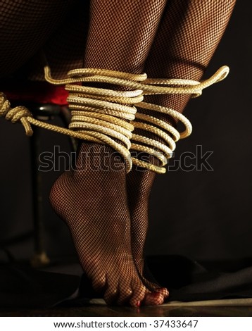 Foot of feet of the girl in stockings are connected by a cord