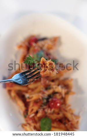 Pasta Penne with spicy sauce al-Arabiata. Penne pasta with spicy sauce in Arabic style with chili, tomato, fresh basil, olive oil and cherry tomatoes, Italian food for a hearty family dinner